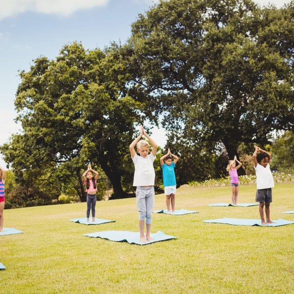 Enfants en séance de yoga dans un parc | Dynamite Moov